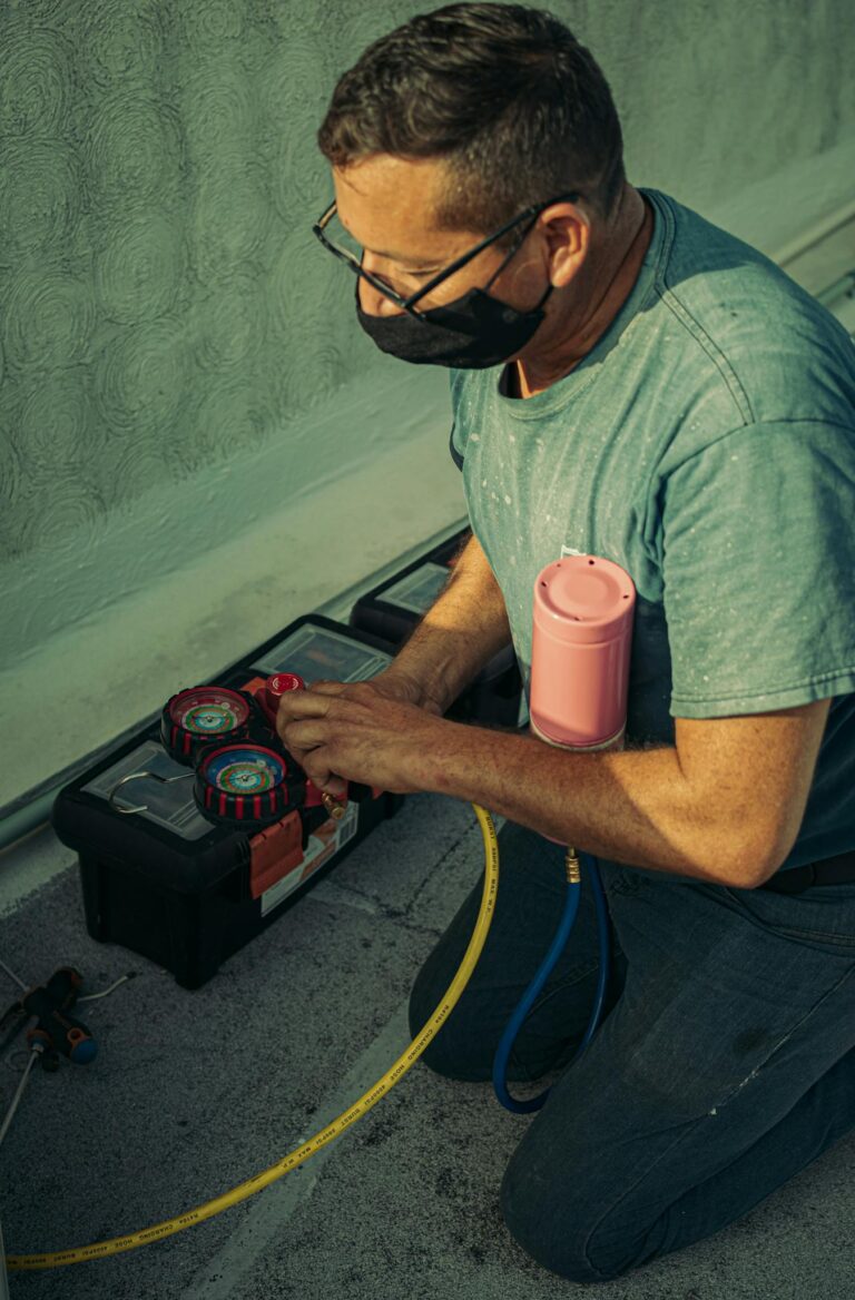 A technician kneels outdoors, performing HVAC maintenance using specialized tools, enhancing system performance.